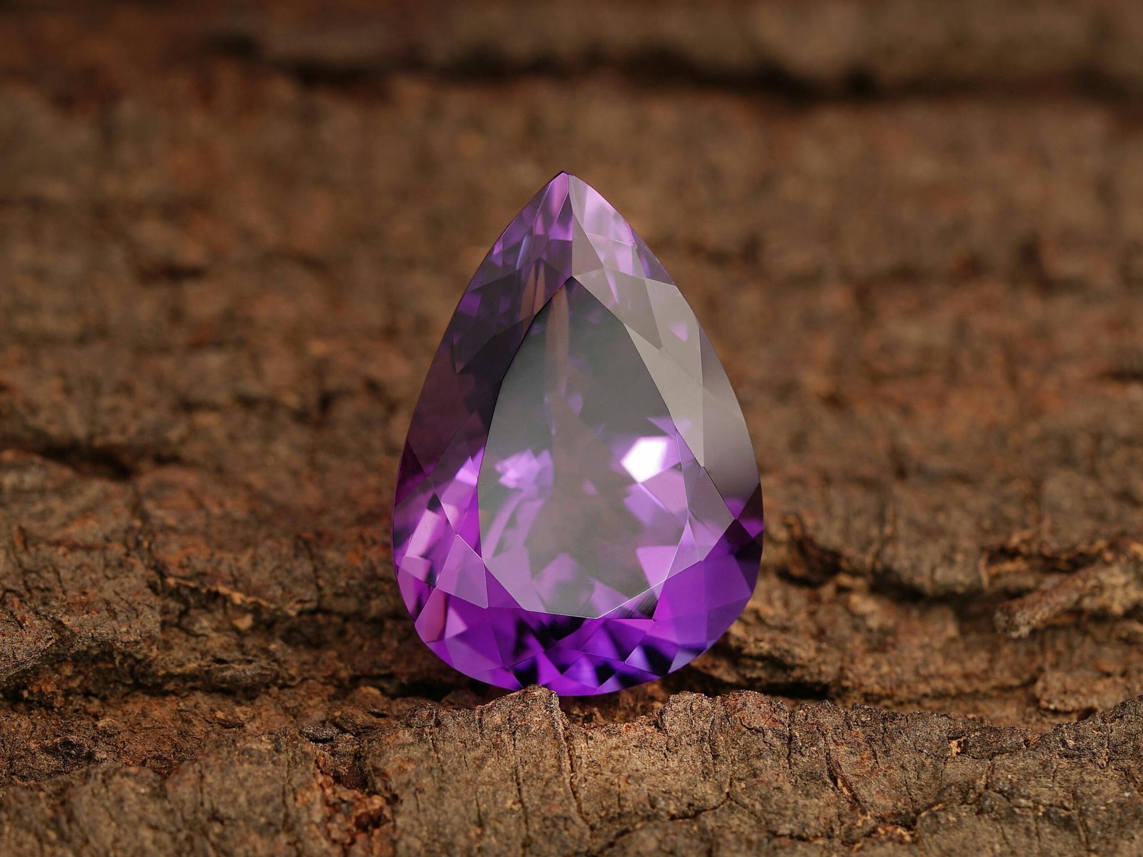 Detailed shot of a polished amethyst gemstone showcasing its vibrant purple hue and clarity.